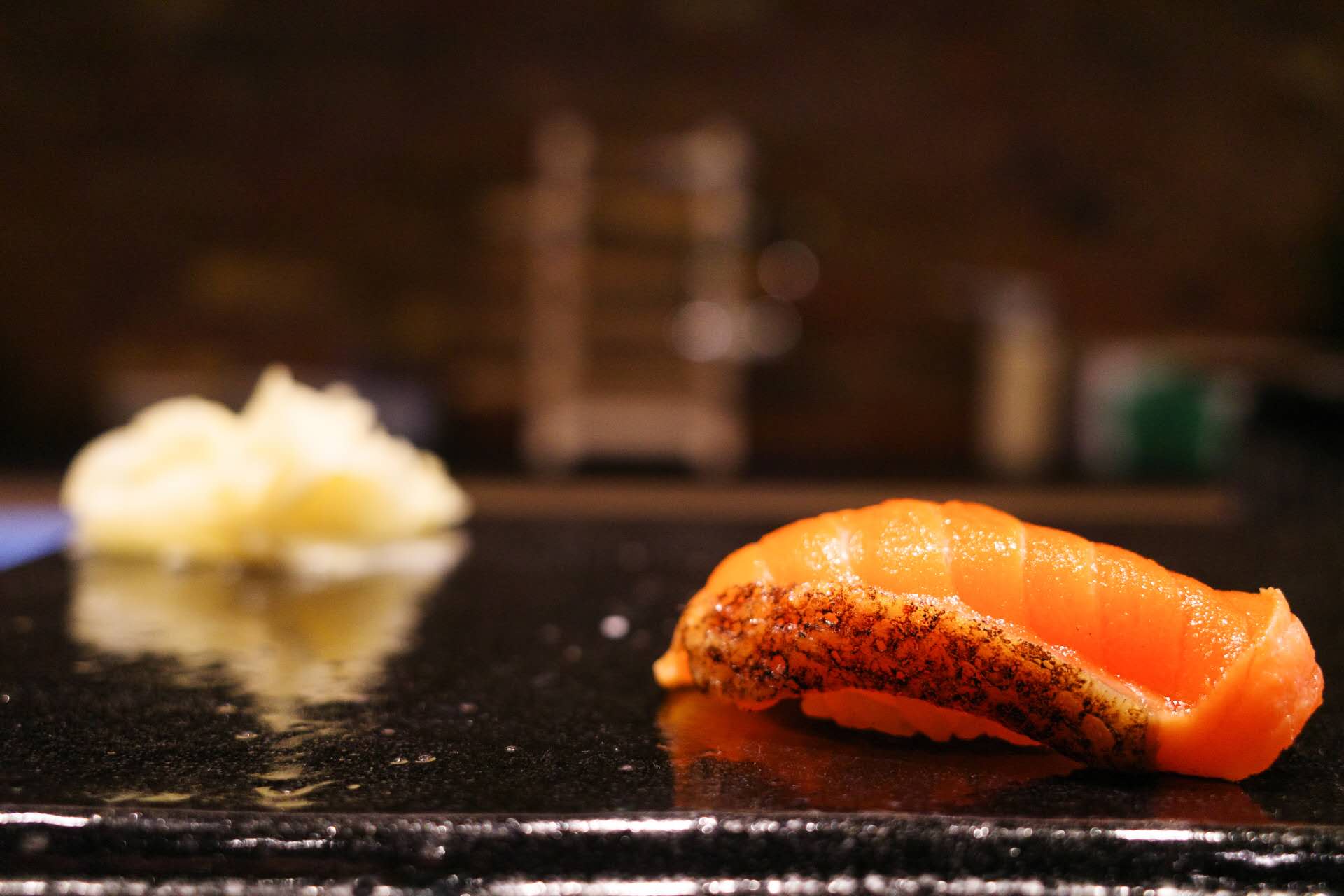 Seared salmon nigiri being prepared live at Kiyoshi Omakase counter
